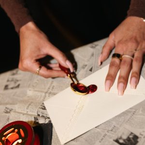 Wax sealing ritual at Typewriters & Bridgerton literary workshop in Toronto featuring vintage correspondence and handwritten letters.