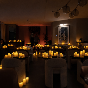 Guests seated at tables in a warmly lit candlelit venue at a Poesy event in Toronto